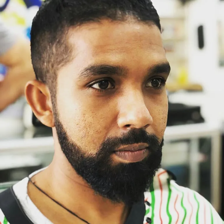 Man with dark full beard and faded sides