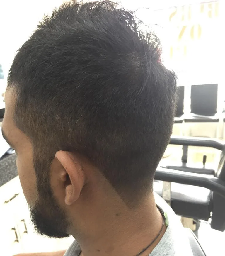 Back of head: textured crop with faded back; partial gold window signage
