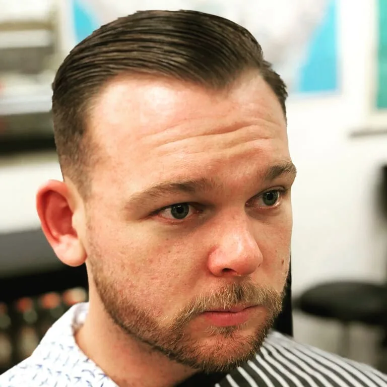 Man with tight slicked-back short cut, close portrait in shop