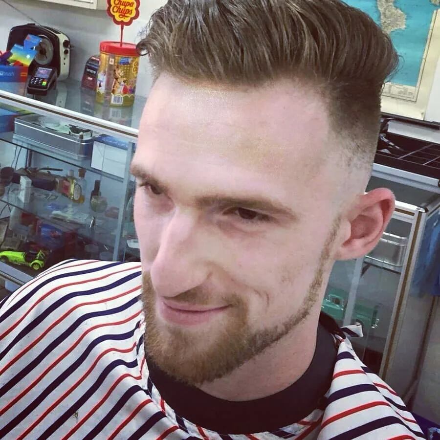 Man with textured quiff; Chupa Chups jar, glass case and map of Italy behind